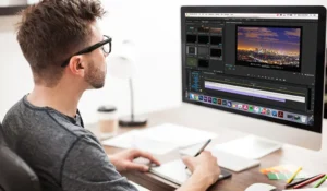A professional video editor doing editing and also paper work setting in front of Computer opening video editing software