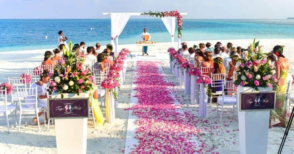 A beach wedding setup with white chairs arranged in rows